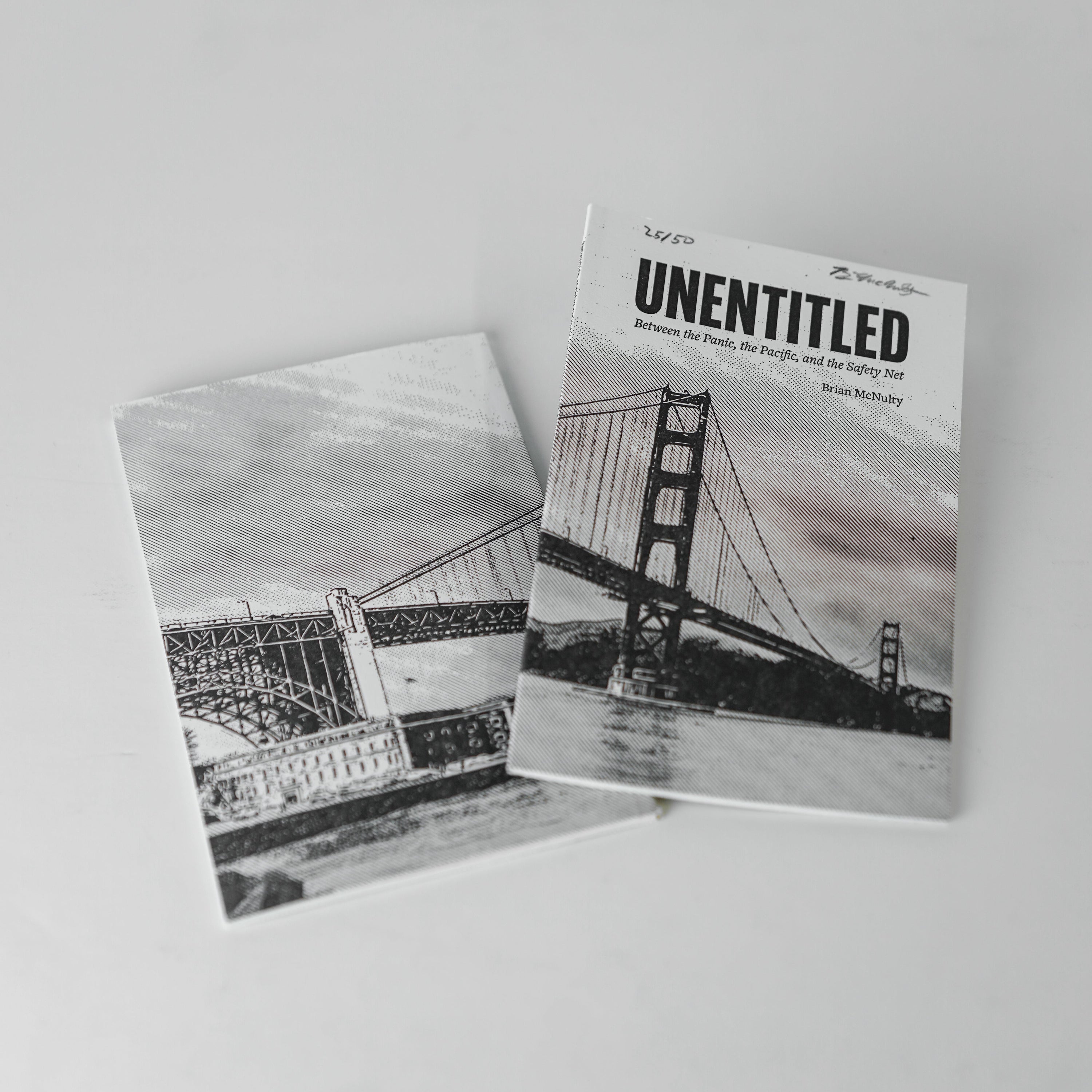 Two books with bridge illustrations on a white surface